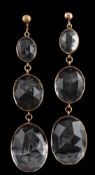 A pair of faceted quartz crystal three-stone drop earrings: each with three graduated oval drops