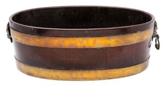 A George III mahogany and brass bound oval jardiniere: of coopered construction with lion mask ring