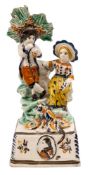 An unusual Prattware pottery commemorative group: of rural child musicians with bocage support,