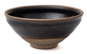 A small Chinese black-glazed bowl: of rounded form with everted rim,