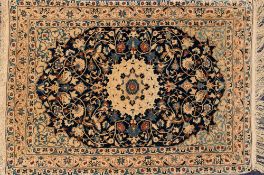 A Nain rug:, the indigo oval cartouche field with a central shaped circular medallion,
