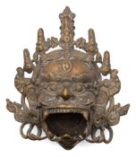 A Tibetan bronze Mahakala mask incense burner: the diety with open mouth and wearing elaborate