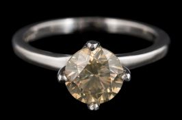 A platinum and diamond solitaire ring: the yellowish brown, round,