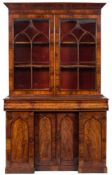 An early Victorian mahogany bookcase:, the upper part with a bevelled cornice,