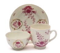 A First Period Worcester trio: painted in puce camaieu with floral sprays,