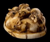 A Japanese carved ivory netsuke: of a group of rats, signed to the oval back Meizen, 3cm. wide.