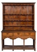 An 18th Century oak dresser:, of small size, the shelved superstructure with pine back and sides,