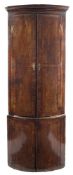 An early 18th Century walnut, crossbanded and feather strung bow-fronted standing corner cupboard:,