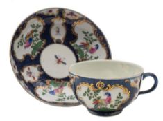 A First Period Worcester blue scale coffee cup and saucer: painted with gilt rococo cartouches of