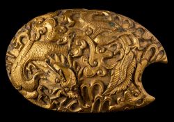 A Chinese gilt bronze dragon belt buckle: cast in relief with a sinuous dragon amongst flame