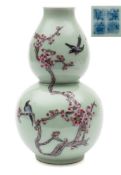A Chinese famille rose double gourd vase: painted with birds and branches of pink blossom on a