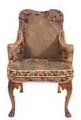 A carved walnut armchair in the early 18th Century taste:, upholstered in gros-point tapestry,