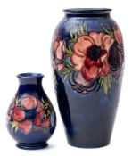 A Moorcroft pottery ovoid vase and a later smaller baluster vase: both tube lined and decorated in