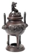 A Japanese bronze twin handled incense burner: the pierced cover with dragon finial,