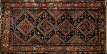 A Melayer rug:, the indigo field with four serrated lozenge and geometric flowerhead medallions,
