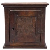 A late 17th Century oak spice cupboard:, with a moulded cornice and interior shelf,