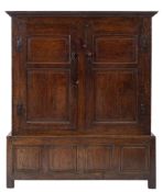 An 18th Century oak side cupboard:, the upper part with a moulded cornice,
