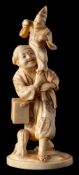 A Japanese carved ivory okimono of a Puppeteer, signed Gyokushi: holding a puppet above his head,