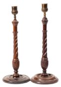 A matched pair of mahogany barley twist candlesticks: with cast brass acanthus decorated nozzles,