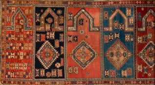 A Shirvan Saph or family prayer rug:, having seven geometric mihrabs in colours of brick red,