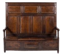 An 18th Century oak box settle:, with a high moulded panel back,