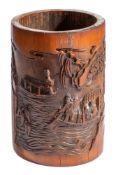A Chinese bamboo brush pot: the cylindrical body carved with scholars at a table and a lake scene