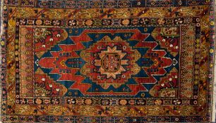 A Hamadan rug:, the indigo and brown serrated field with a central geometric medallion,