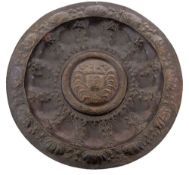 A large Newlyn copper charger: embossed with central pseudo-crest within a wreath,