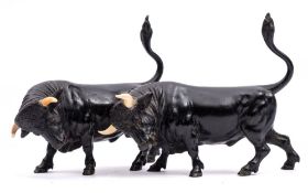 A pair of late 19th Century Viennese cold painted bronze and ivory models of confronting bulls: one