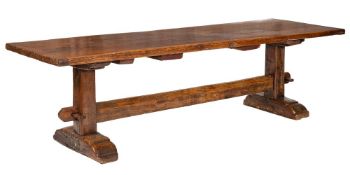 An oak refectory table: with a three plank cleated top, on dual trestle end supports,