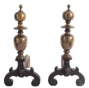 A pair of late 16th Century bronze and wrought iron andirons: the scroll legs centred by lion masks,