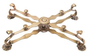 A mid 18th Century brass dish cross: with shaped hinged arms and cast shell feet,
