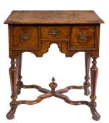 A William & Mary walnut and feather banded lowboy: the rectangular quarter veneered top with a