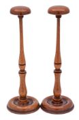 A pair of finely turned 19th Century mahogany wig stands: the domed tops on slender ring turned and
