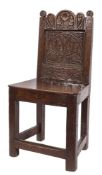 A 17th Century carved oak child's chair: the back with shaped arcaded top rail with flowerhead and