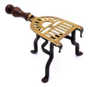 A miniature pierced brass and iron trivet: of horseshoe outline,