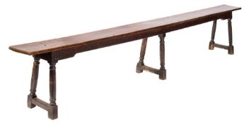 A late 17th Century/early 18th Century oak bench:, on six turned and splayed legs,