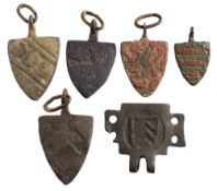 Six late Medieval horse harness pendants: includes five shield-shaped examples and a rectangular