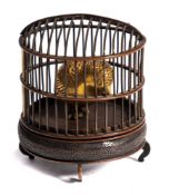 A Japanese bronze okimono: of a gilded bird in a cage, mounted on a circular stand, unsigned,