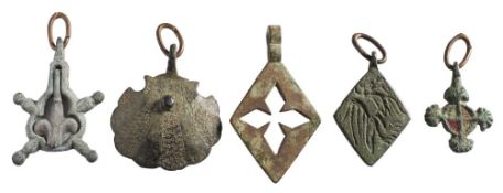 Five late Medieval horse harness pendants: includes scallop shell pendant, open work diamond,