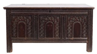 An early 17th Century carved oak rectangular coffer: with a plain hinged moulded top,