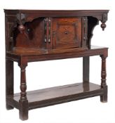 A 17th Century oak livery cupboard:, the top with a moulded pendant hung frieze,