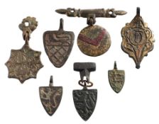 Seven late Medieval horse harness pendants: includes four shield-shaped examples,