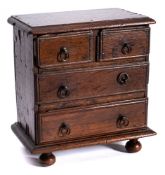 A 17th Century miniature oak chest of drawers: the rectangular top with a moulded edge containing