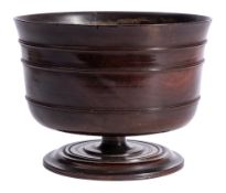 A 17th Century lignum vitae pedestal wassail bowl: of traditional design with reeded ring turned