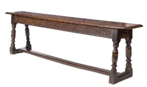 A 17th Century oak West Country bench: the top with moulded edge,