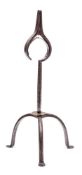 An 18th Century iron rushlight of rare form: on tripod base with brass disc at the base of the stem,
