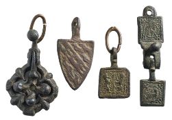 Four late Medieval horse harness pendants: includes quatrefoil 'fleur' suspension,