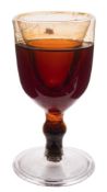 A deception wine glass: probably American and of hollow construction with ogee bowl and knopped