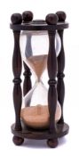 An early 19th Century rosewood framed sand glass: with turned baluster cage raised on ball feet, 16.
